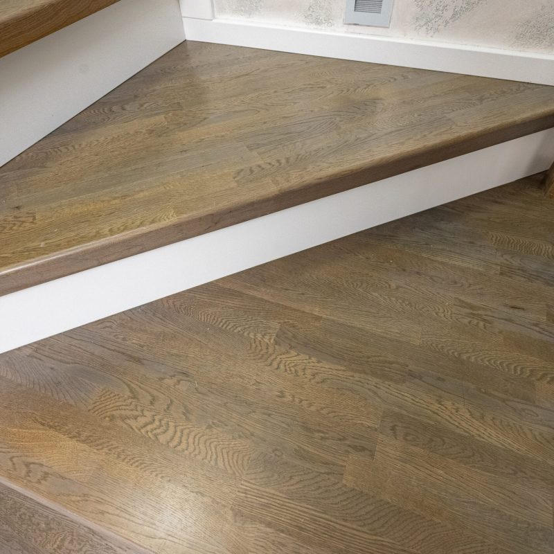 Облицовка бетонной лестницы дубом с широкой первой ступенью